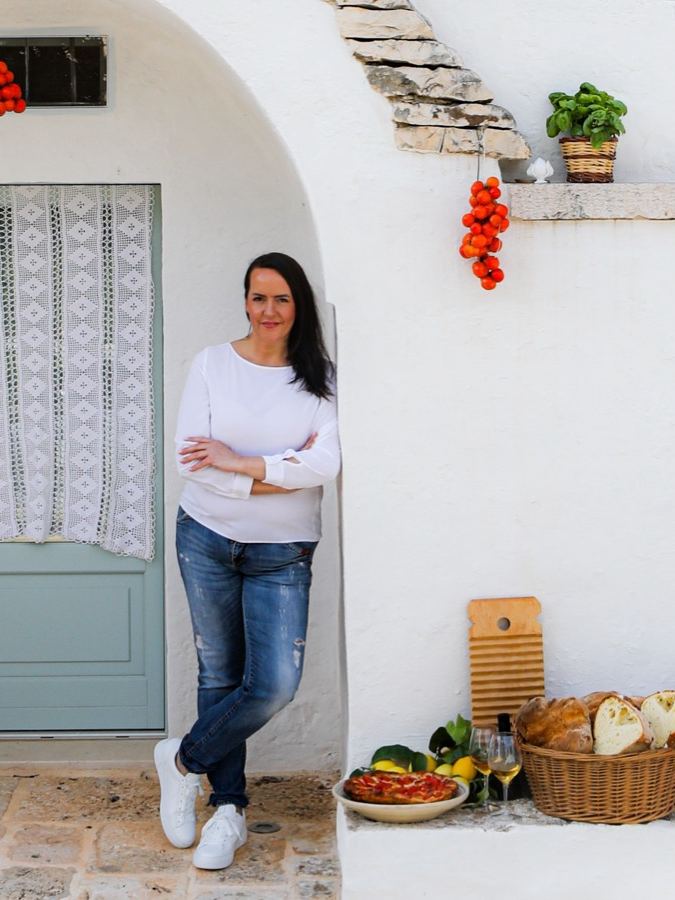 Stefania Lettini vor einem weiß getünchten Haus in Apulien